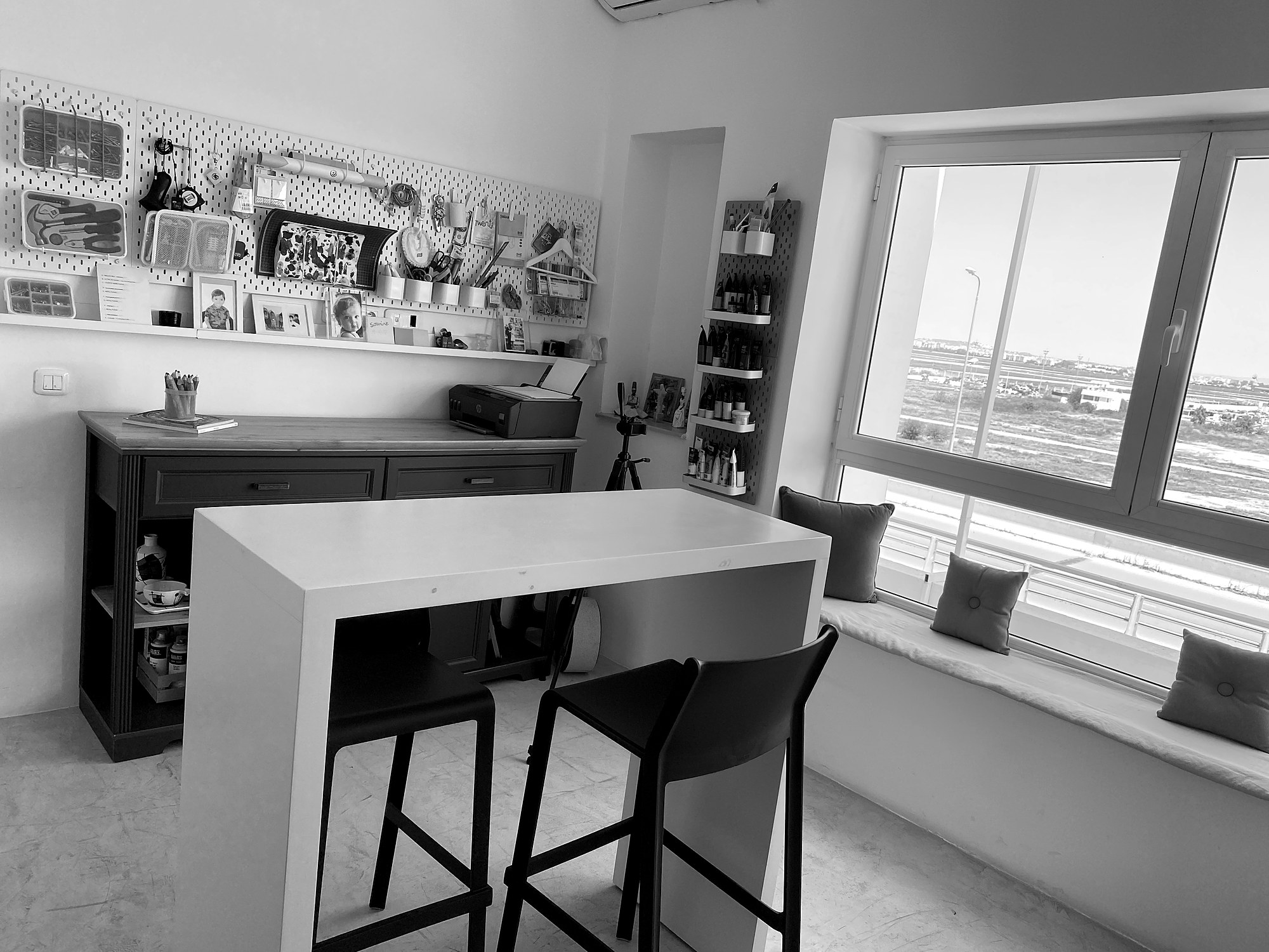 Un espace breakout du studio Dooni : mur pegboard, table haute et banquette sous la fenêtre.